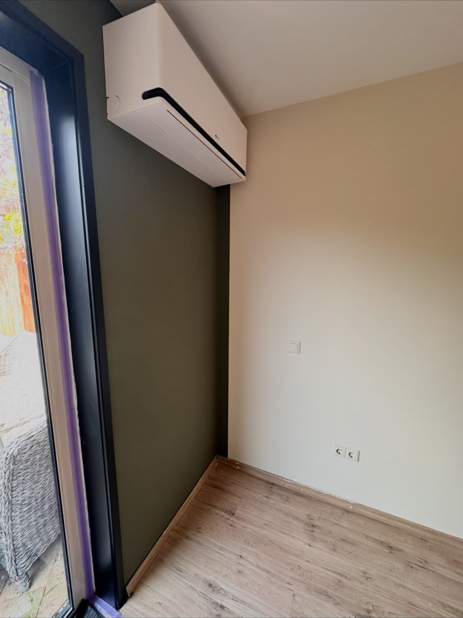 Kamer met olijfgroene en lichte wand naast schuifpui